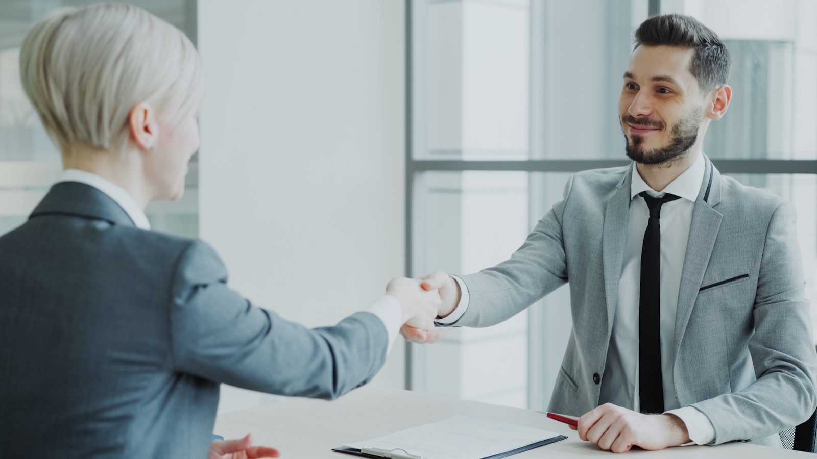 Professionals shaking hands across a meeting table